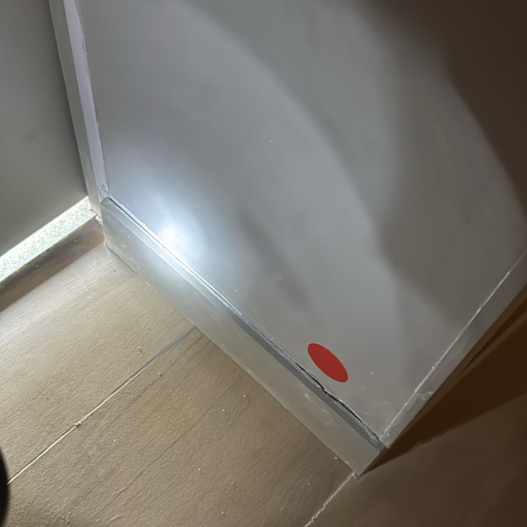 Detecção de parede com acabamento irregular e vícios construtivos aparentes durante vistoria técnica.