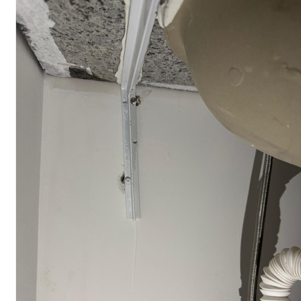 "Vistoria técnica de obra no RJ identificando cantoneira de acabamento torta em forro de gesso, um vício construtivo aparente.